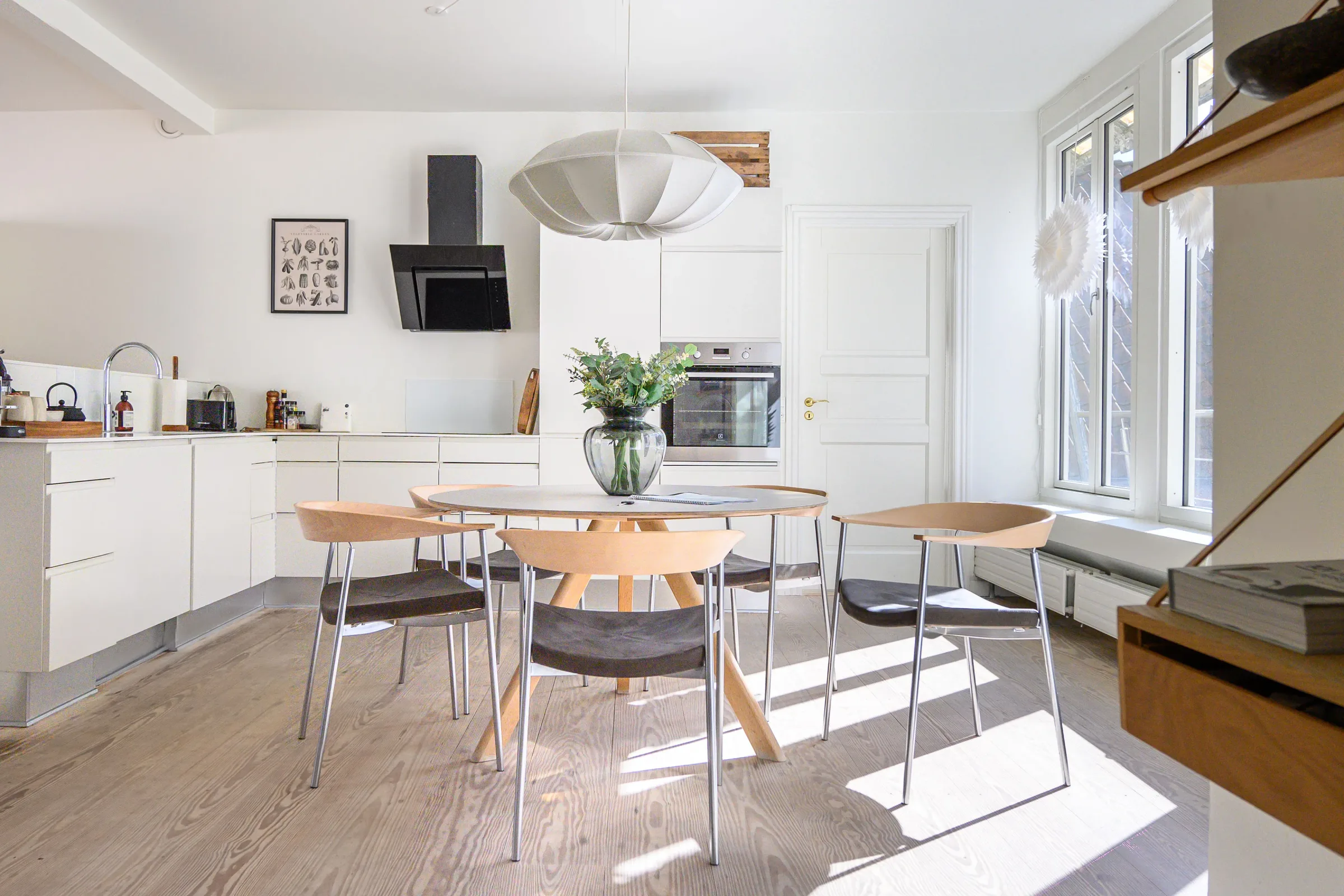 White kitchen and round dining table — Chic Nordic Apartment, central Copenhagen