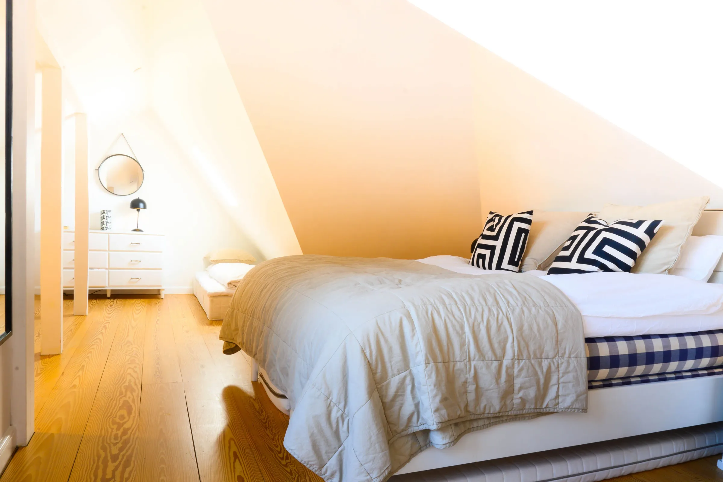 Bright attic bedroom with a double bed under a sloping ceiling — Luxury Apartment, central Copenhagen