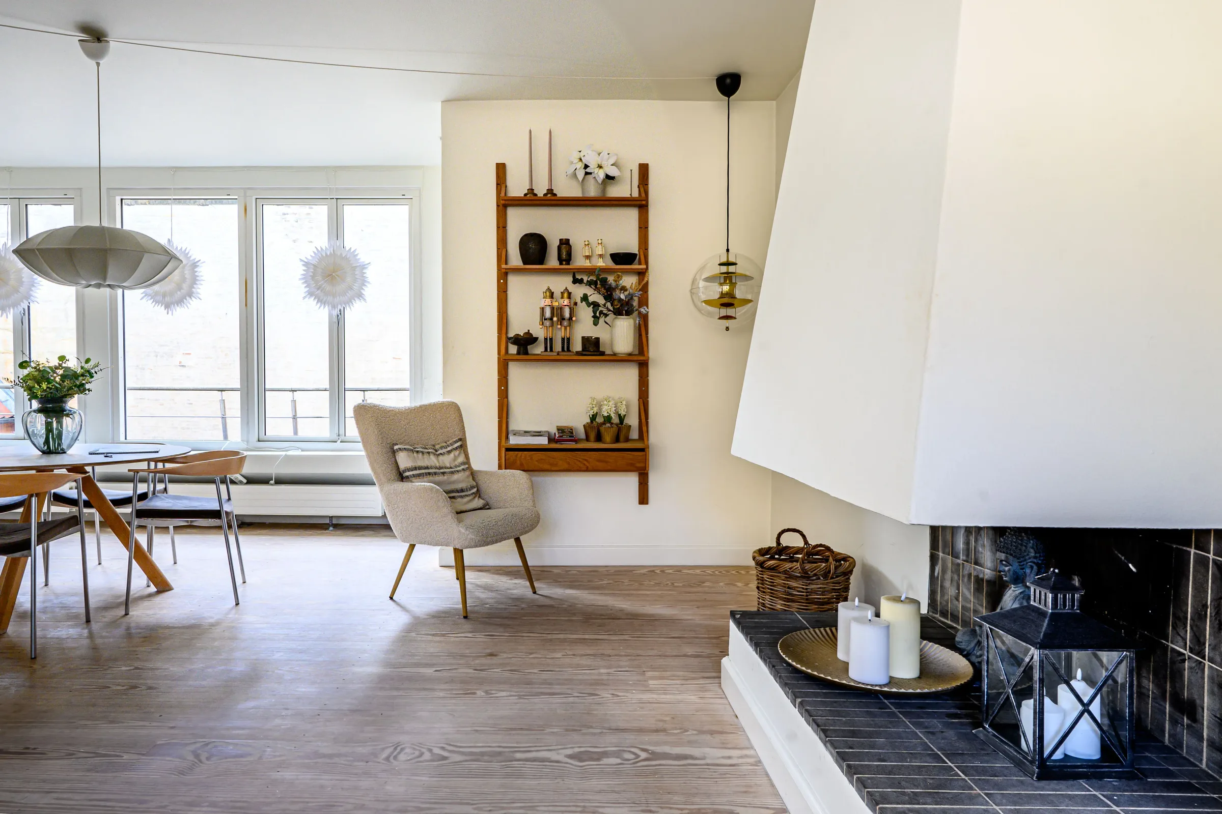 Bright open-plan living and dining room with a sculptural white fireplace in a Best Stay Copenhagen apartment